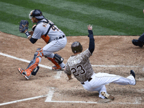 San Diego's Yonder Alonso, right, scores ahead of the throw to Victor Martinez of the Tigers during the fourth inning Sunday  at Petco Park in San Diego. (Photo by Denis Poroy/Getty Images)