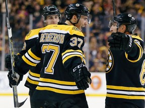 Boston's Patrice Bergeron, left, celebrates his goal with Brad Marchand, right, and Matt Bartkowski against the Buffalo Sabres. (AP Photo/Michael Dwyer)