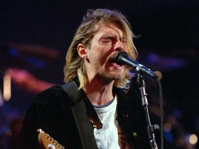 FILE - This Dec. 13, 1993 file photo shows Kurt Cobain of the Seattle band Nirvana performing in Seattle, Wash. Nirvana, which changed music and fashion in the 1990s with the punk rock-inspired grunge sound, is joining the Rock and Roll Hall of Fame in a class with Kiss, Peter Gabriel and Hall & Oates. Nirvana is being inducted in its first year of eligibility. The trio's "Smells Like Teen Spirit" hit like a thunderclap upon its 1991 release, briefly making the Pacific Northwest rock's hottest scene before the band ended abruptly with singer Kurt Cobain's suicide in 1994. (AP Photo/Robert Sorbo, File)