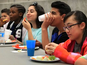 Ecole secondaire Michel-Gratton students Erika Ntchana, left, Yara Houssami, Adnan Nadi, Christina Tran, right, enjoy healthy lunch as MPP Teresa Piruzza, Minister of Children and Youth Services announced an expansion of the Student Nutrition Program Monday April 7, 2014. (NICK BRANCACCIO/The Windsor Star)
