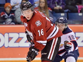 Ex-Spit Kerby Rychel, left, is checked by Saginaw's Dylan Sadowy. (TERRY WILSON/OHL Images)