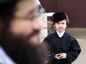 The child of Lev Tahor spokesperson Uriel Goldman looks up at his father speak to the media in Chatham, Ontario on April 14, 2014. The ultra-orthodox religious group has won an appeal in the child protection case. (JASON KRYK/ The Windsor Star)