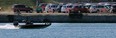 A fishing boat motors on the Detroit River in front of thousands of Windsor-built Chrysler Town and County and Dodge Grand Caravans parked on Detroit, Michigan riverfront waiting to be transported by rail, Wednesday April 23, 2014. (NICK BRANCACCIO/The Windsor Star)