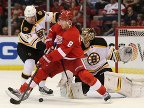 Detroit's Justin Abdelkader, centre, is checked by Boston's Dougie Hamilton, left, if front of Bruins goalie Tuukka Rask Tuesday at Joe Louis Arena. (Photo by Leon Halip/Getty Images)