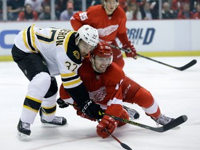 Boston's Patrice Bergeron, left, checks Detroit's Riley Sheahan during the first period of Game 3 in Detroit. (AP Photo/Carlos Osorio)