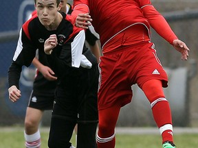 Cardinal Carter's Andrew Vale, right, and Forster's Lutifei Abulititu battle in high school boys soccer Monday at Forster. (TYLER BROWNBRIDGE/The Windsor Star)