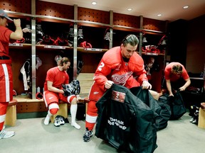 Detroit defensemen Danny Dekeyser, from left, Niklas Kronwall, Brendan Smith and Jakub Kindl pack their bags after the team photo was taken Tuesday at Joe Louis Arena. (AP Photo/Carlos Osorio)