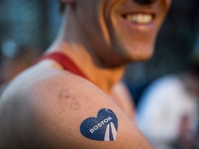 A runner with a temporary Boston Marathon tattoo gets ready to run the 118th Boston Marathon in the Boston Commons on April 21, 2014 in Boston, Massachusetts. (Photo by Andrew Burton/Getty Images)