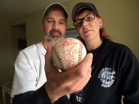 Rob Lucier and Ali McCabe display a Major League Baseball official ball given to McCabe after she caught Miguel Cabrera's 2,000th hit recently at Comerica Park.  McGabe gave the actual ball to Comerica Park officials and in return they gave her an autographed ball.  (JASON KRYK/The Windsor Star)