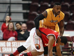 The Windsor Express' Stefan Bonneau is helped up by the Island Storm's Nick Okorie after the two collided at the WFCU Centre in Windsor during game one of the championship final on Friday, April 4, 2014.                          (TYLER BROWNBRIDGE/The Windsor Star)