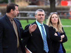 Const. Anthony Fanara (centre) of Windsor police heads to his hearing with his wife (right) and Ed Parent (left) of the Windsor Police Association on April 24, 2014. (Nick Brancaccio / The Windsor Star)