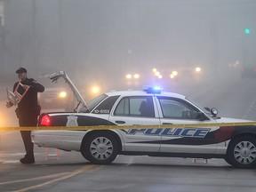 A Windsor police officer mans a barricade Friday, April 4, 2014 on Lauzon Road near Tranby Avenue in Windsor, Ont. (DAN JANISSE/The Windsor Star)