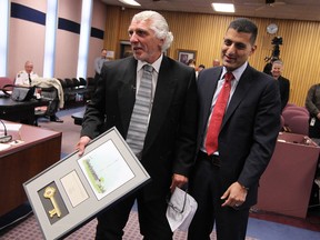 CBC municipal reporter Gino Conte, left, receives the Key to the City from Windsor Mayor Eddie Francis, right, on the occasion of Conte's last council meeting as a media professional. Conte is retiring after 40 years in the news industry. Photographed April 28, 2014. (Tyler Brownbridge / The Windsor Star)
