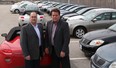 Mickey Pierre and Jerry Revenberg at Gus Revenberg Chevrolet Buick GMC stand with a lot full of recalled vehicles in line to be repaired at the east Windsor dealership. (JASON KRYK/The Windsor Star)