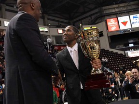 Windsor Express owner Dartis Willis, right, receives the championship trophy from commissioner Paul Riley after beating the Island Storm in Game 7 of the NBL championship final at the WFCU Centre. (TYLER BROWNBRIDGE/The Windsor Star)