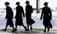 Members of the Lev Tahor ultra-orthodox Jewish sect walk down a street while an emergency motion in the child custody case is held at the courthouse in Chatham, Ont., Wednesday, March 5, 2014. THE CANADIAN PRESS/Dave Chidley
