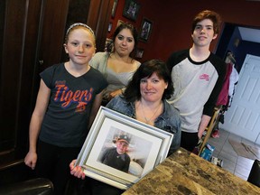 Annie Kisch holds a photograph of her son Holden, who died in February, as she is joined by her other children Aubri, left, Emma and Mikey at their home in LaSalle on Thursday, April 24, 2014. (TYLER BROWNBRIDGE/The Windsor Star)