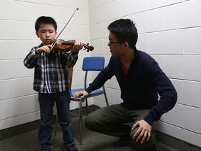 Zeyu Li, age 6, practises on the violin with instruction from his music teacher Yuchen Dai at the  2014 Kiwanis Music Festival held at the University of Windsor School of Music on April 22, 2014 in Windsor, Ontario.   The Kiwanis Music Festival offers a unique opportunity for local music students to hone their musical skills, showcase their talents and gain confidence in their musical abilities through live, adjudicated performances.  Brass, choir, harp, mixed ensembles, percussion, strings, voice and woodwinds competition runs from  April 22 to 25.  Piano and speech arts and drama runs from April 28 to May 2. (JASON KRYK/The Windsor Star)