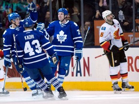 Flames defenceman Mark Giordano, right, reacts as Maple Leafs forward David Clarkson , right, is congratulated by teammates Nazem Kadri and Mason Raymond, left after scoring the game winning goal during third period NHL action in Toronto on Tuesday April 1, 2014. (THE CANADIAN PRESS/Frank Gunn)