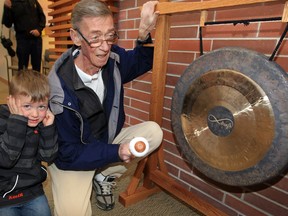 Cancer patient Alex Moffat (R) celebrates the last day of his treatment by banging a gong at the Windsor Regional Cancer Centre on April 9, 2014. Grandson Easton Moffat looks on. (Nick Brancaccio / The Windsor Star)