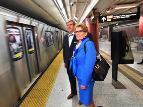 Ontario Premier Kathleen Wynne and Glen Murray, Minister of Infrastructure, wait to board the subway. THE CANADIAN PRESS/Darren Calabrese