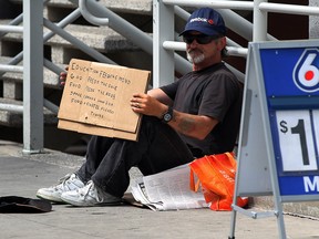 A downtown Windsor panhandler is shown on Ouellette Avenue in this 2013 file photo. (Nick Brancaccio / The Windsor Star)