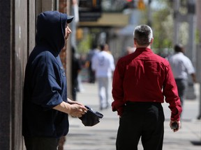 A panhandler begs for money in downtown Windsor in this 2011 file photo. (Tyler Brownbridge / The Windsor Star)