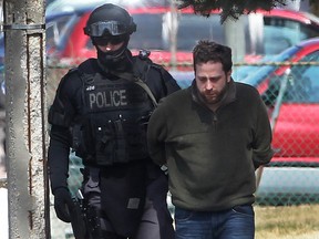 A Windsor police tactical team member takes an unidentified male into custody in the 600 block of Pierre Avenue on April 2, 2014. The male was a suspect in an assault incident earlier that morning. (Dan Janisse / The Windsor Star)