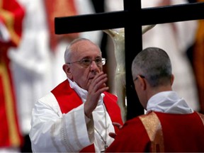 Pope Francis kisses the cross as he attends a Papal Mass with the Celebration of the Lord's Passion inside St Peter's Basilica on April 18, 2014 in Vatican City, Vatican.  (Franco Origlia/Getty Images)