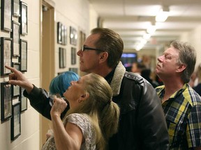 Renee Auger, front, Richard Monk, 48, and Bruce Langlois, 49, right, look through old graduation photos from the 60's and 70's from Dr. H.D. Taylor Public School where they all graduated from while at the school's Learning Farewell Open House Saturday, April 26, 2014.  (DAX MELMER/The Windsor Star)