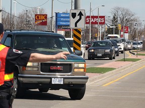 A police officer detours traffic Friday, April 11, 2014, at the intersection of Tecumseh Rd. E. and Rose-Ville Garden Dr. in Windsor, Ont. The westbound lanes were closed for over two hours as police investigated an accident involving a truck and a pedestrian. Witnesses said the female pedestrian had a bloody head injury. (DAN JANISSE/The Windsor Star)