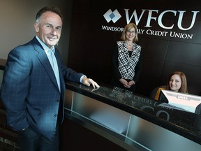 Marty Komsa, left, president/CEO, and Sheila Geddes, vice president Human Resources, chat with Kelly Tiede, member relations consultant, as she works at the WFCU head office in Windsor on Thursday, April 17, 2014.  (TYLER BROWNBRIDGE/The Windsor Star)