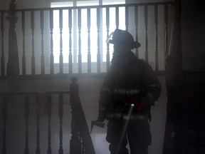 A Windsor firefighter walks through a smoke-filled home during a simulated fire on Fazio Drive in Windsor, Ontario on April 30, 2014.  (JASON KRYK/The Windsor Star)