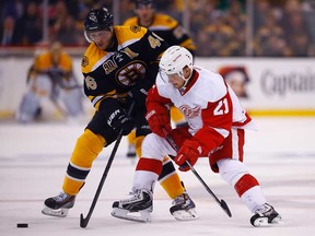 Detroit's Tomas Tatar, right, battles for the puck against Boston's David Krejci during in Game 1 of their first-round series at TD Garden on April 18, 2014 in Boston, Massachusetts.  (Photo by Jared Wickerham/Getty Images)