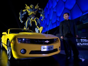 A Chevrolet Camaro is displayed near the character the car transforms into in the movie Transformers during an event held ahead of Auto China 2014 in Beijing on Saturday. (Ng Han Guan / The Associated Press)
