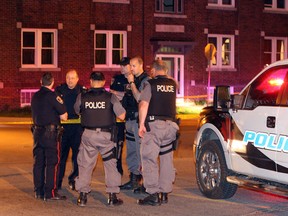 Windsor Police Sgt. Steve Betteridge, second from left, confers with other police officers at the corner of Erie Street East and Pierre Avenue following a shooting which sent at least one person to hospital Thursday May 8, 2014. (NICK BRANCACCIO/The Windsor Star)