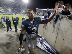 BYU  linebacker Kyle Van Noy high-fives fans as he walks off the field following a game against Middle Tennessee. (AP Photo/Rick Bowmer, File)