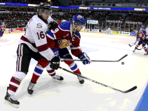 Tecumseh's Kerby Rychel, left, battles for the puck with Edmonton's Griffin Reinhart during the second period at the Memorial Cup in London Saturday. (THE CANADIAN PRESS/Dave Chidley)