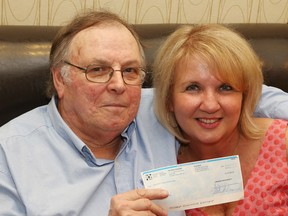 Leo and Jennifer Innocente hold their $1-million dollar cheque on May 21, 2014, after winning the Canadian Cancer Society's Lottery Grand Prize.  (JASON KRYK/The Windsor Star)