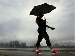 An umbrella toting walker strolls along the downtown Windsor, Ont. riverfront on a foggy and rainy Monday, May 12, 2014. (DAN JANISSE/The Windsor Star)