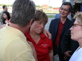 Premier Kathleen Wynne, right, and MPP Michael Chan watch and listen as former CAW president Ken Lewenza, left, talks into the ear of MPP Teresa Piruzza as Wynne made her way to her campaign bus Tuesday May 20, 2014.  Hundreds of supporters jammed the small office to hear and see Premier Wynne.   (NICK BRANCACCIO/The Windsor Star)