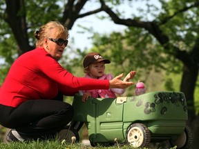 Grandma Wioletta Pendziwiatr and granddaughter Mia Bakos, 2, watch as workers continue with excavation work for new pathway around Willistead Park Tuesday May 20, 2014. Mia was keenly interested in the heavy machinery and digging at the popular Walkerville park.  (NICK BRANCACCIO/The Windsor Star)