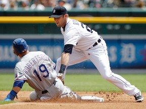 Detroit's Andrew Romine, right, tags out Dan Robertson of the Rangers at second base in the first inning at Comerica Park. (Photo by Duane Burleson/Getty Images)