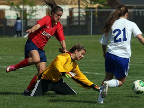 St. Anne goalie Erica Greco, centre, holds off Holy Names Breanna Grandmaison, left,  as Kylene Dupuis gathers the loose ball in senior girls soccer action from McHugh Park Thursday. (NICK BRANCACCIO/The Windsor Star)