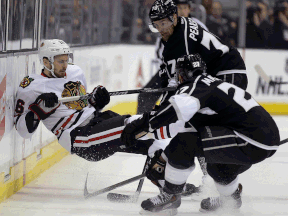 Chicago's Marcus Kruger, left, is checked by Kings defenceman Alec Martinez, and winger Tanner Pearson during the first period of Game 3 of the Western Conference finals. (AP Photo/Chris Carlson)