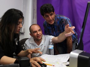 Helmi Charif, right, independent candidate in Windsor-West checks in with Chadi Abdullah and Sabreen Khocheich, left, both team members at his Wyandotte Street East office, Monday May 26, 2014. (RICK DAWES/The Windsor Star)