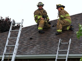 Tecumseh firefighters check the roof of a family home at 12366 Meconi Drive after a lightning strike which caused some damage to the structure of the home Tuesday May 27, 2014.  There were no injuries. (NICK BRANCACCIO/The Windsor Star)