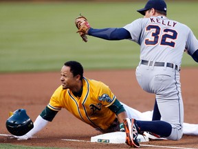Oakland's Coco Crisp, left, is tagged out on a third base steal attempt by Detroit third baseman Don Kelly during the first inning Tuesday in Oakland. (AP Photo/Beck Diefenbach)