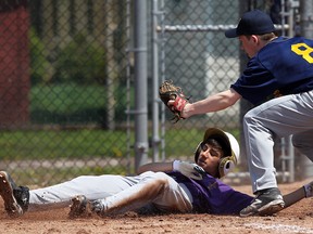 Kingsville's Darian Gray, left, slides under the tag from Kennedy's Joey Bray at Walker Homesite Park in Windsor. (TYLER BROWNBRIDGE/The Windsor Star)