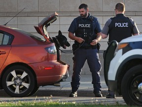 Windsor police draw their guns on a stopped car at the intersection of Church Ave. and Riverside Dr. East, Saturday evening, May 24, 2014.  One occupant of the vehicle was taken into custody.  (DAX MELMER/The Windsor Star)